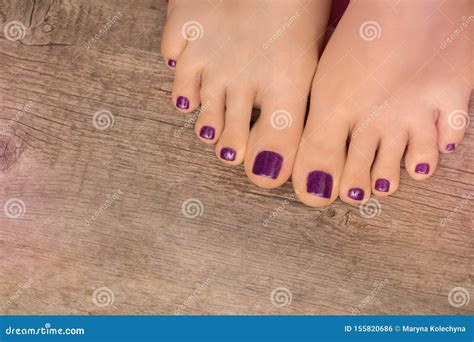 Beautiful Female Feet With Purple Pedicure On Wooden Background Stock