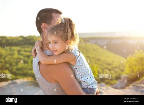 The Father And Daughter Hug Tightly The Girl Holds The Father By The