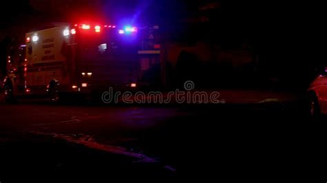 Ambulance Flashes Its Lights During A Paramedics With Night City Stock