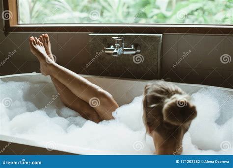 Woman Relaxing In Foam Bath With Bubbles In Dark Bathroom By Window Stock Photo Image Of