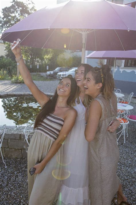 Cheerful Girls Taking Selfie Via Phone In Outdoor Cafe Del Colaborador De Stocksy Rolfo