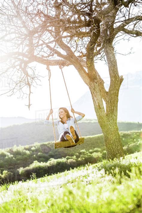 Caucasian Woman Swinging On Tree Swing Stock Photo Dissolve