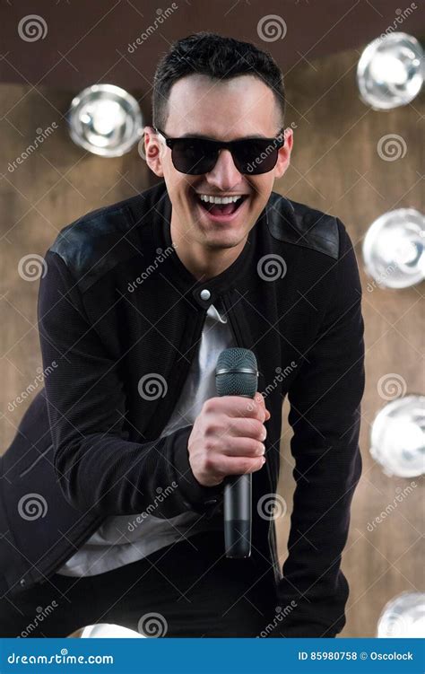 Male Singer In Sunglasses With Microphone Sings In Projectors Li Stock