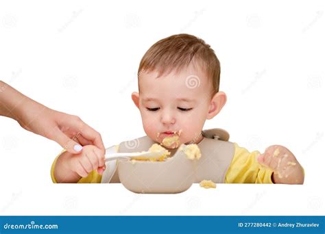 Mother Teaches Toddler Baby Boy To Eat Porridge With A Spoon While Sit