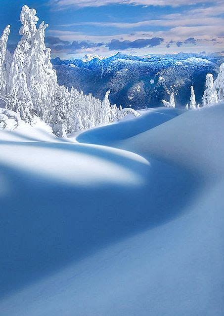 A Person On Skis In The Snow With Mountains And Clouds Behind Them As