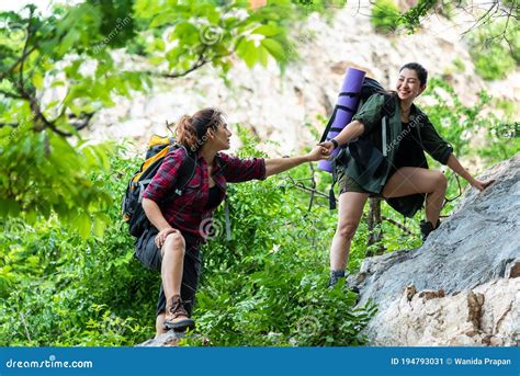 Group Hiker Woman Helping Her Friend Climb Up The Last Section Of