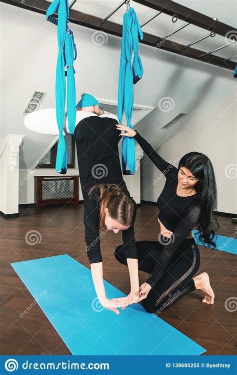 Yoga In A White Room Girls Performs Physical Exercises Fly Yoga Pilates On A Special Equipment