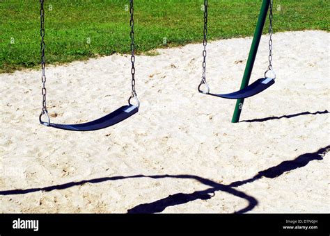 Empty Swings On Sandy Playground Stock Photo Alamy