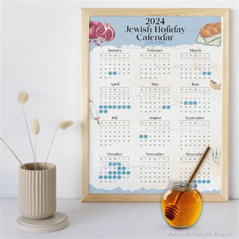 A Jewish Holiday Calendar Next To A Vase With Flowers In It And A Honey Jar