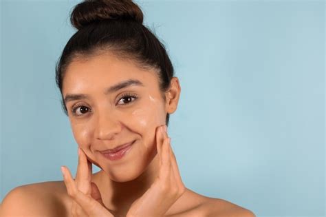 Premium Photo Latin Teen Girl Rubbing Her Face With Cream