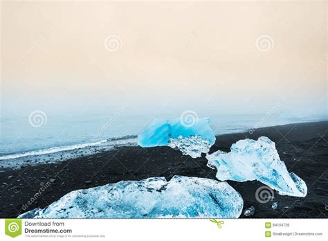 Blue Icebergs On The Beach With Black Volcanic Sand Stock