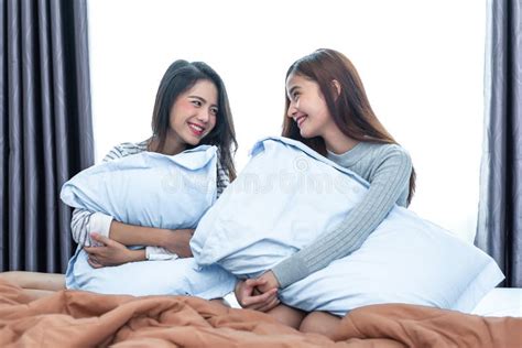 close up of two asian lesbian women looking together in bedroom stock image image of happy