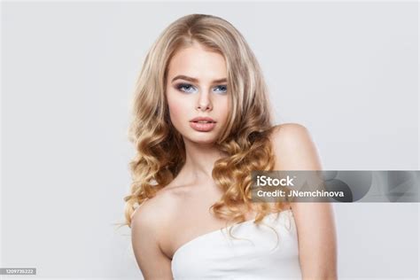 wunderschöne modell frau mit langen blonden lockigen haaren auf weißem hintergrund stockfoto und