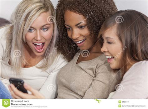 Beaux Amis De Femmes De Groupe Interracial Employant Smartphone Image