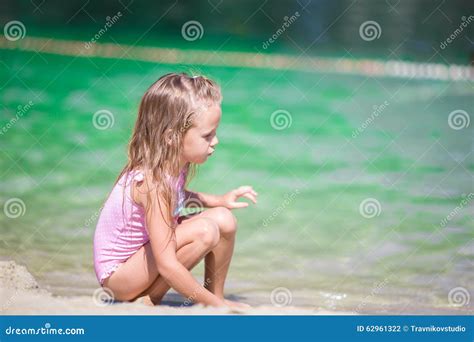 Прелестная маленькая девочка на пляже во время лета Стоковое Фото изображение насчитывающей