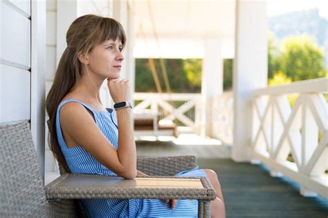 Side View Of Young Beautiful Woman Resting On Fresh Air Sitting On Porch At Home Concept Of