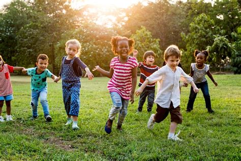 Grupo De Niños Diversos Jugando Juntos En El Campo Foto Premium