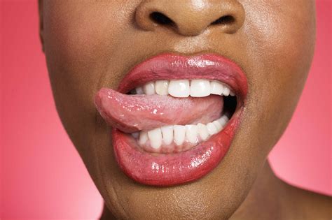 Picture of tongue sticking out. Close up of woman sticking out tongue - Bury Dental Centre