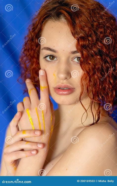 Redhead Curly Woman Hands In Yellow Paint Looks At The Camera Stock Image Image Of Adult