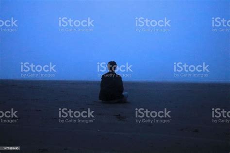Boy Sitting Alone On Misty Beach Stock Photo Download Image Now
