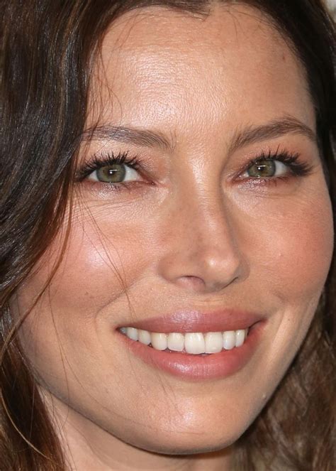 A Close Up Of A Woman With Brown Hair And Green Eyes Smiling At The Camera