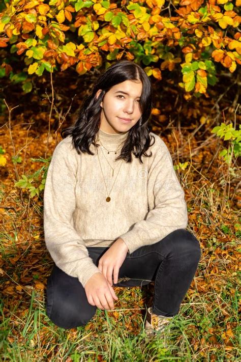 Young Pretty Stylishly Dressed Girl With Beige Sweater And Black Jeans