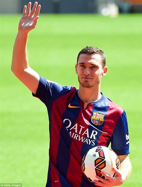 a man holding a soccer ball in his right hand and waving to the sidelines