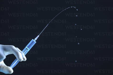 Close Up Liquid Squirting From Syringe Stock Photo