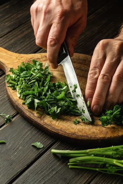 Premium Photo Closeup Of Chef Hands Cutting Green Parsley Leaves On A