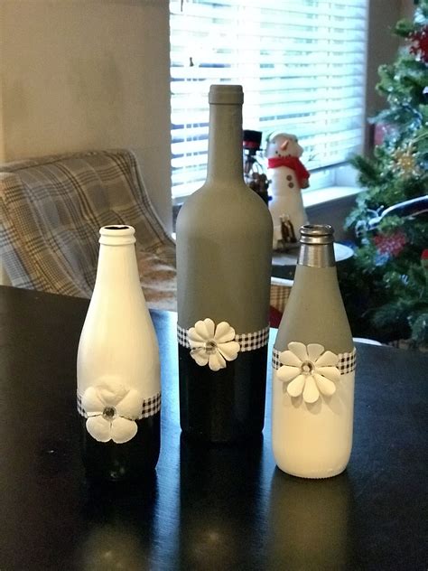 Three Decorated Bottles Sitting On Top Of A Table