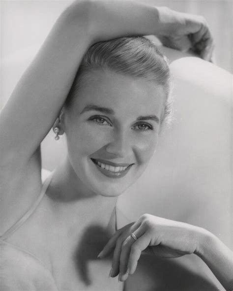 A Black And White Photo Of A Woman Smiling With Her Hands On Her Head
