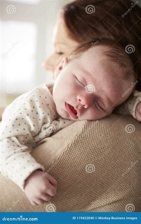 Close Up Of Sleeping Newborn Baby Sleeping On Mothers Shoulder Stock