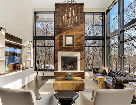 Modern Living Room Features Towering Fireplace Among Floor To Ceiling