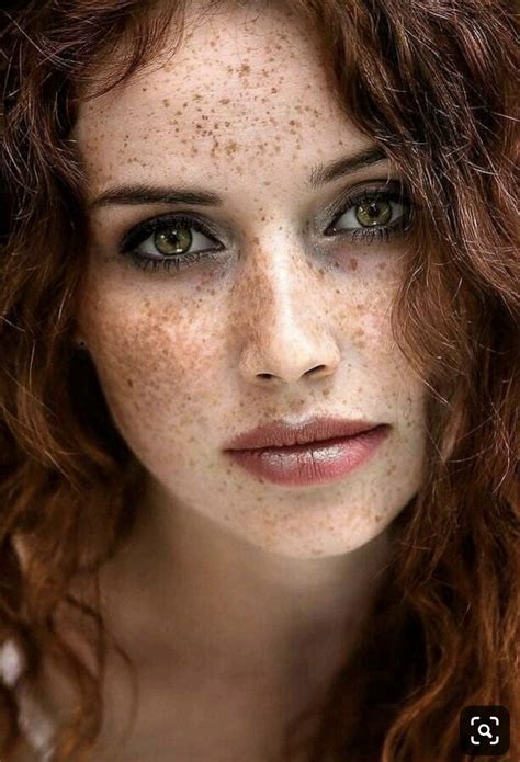 A Woman With Freckles On Her Face And Red Hair Is Looking At The Camera