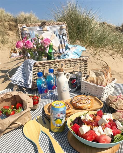 A Picnic On The Beach With Food And Drinks In Baskets Water Bottles