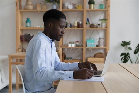 Focused Black Student Guy Watching Learning Webinar On Laptop Stock