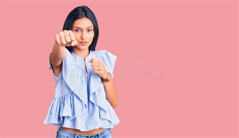 Young Beautiful Latin Girl Wearing Casual Clothes Punching Fist To