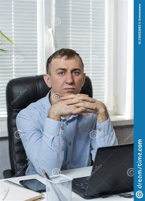 Serious Young Businessman Sitting And Using Laptop At Office Portrait