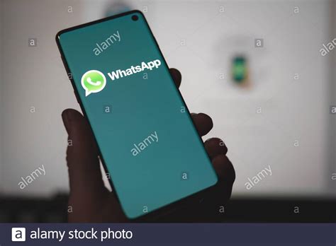Man Holding A Smartphone With Whatsapp Messenger App Logo Displayed On