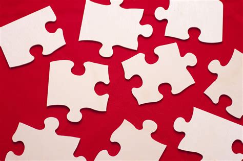 Free Image Of Scattered White Puzzle Pieces On A Red Background