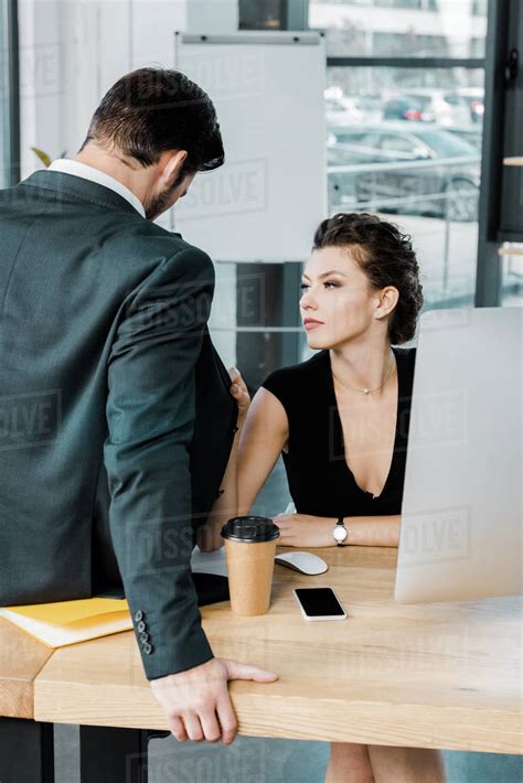 Young Seductive Businesswoman Flirting With Colleague At Workplace In