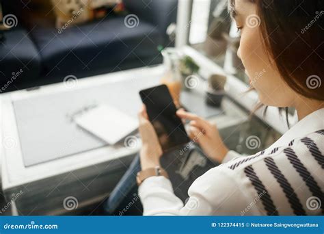 Young Businesswoman Sitting In Workplace And Using Mobile Phone Stock