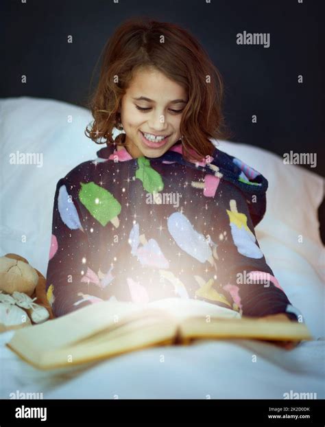 la historia cobra vida foto recortada de una niña leyendo un libro en la cama fotografía de
