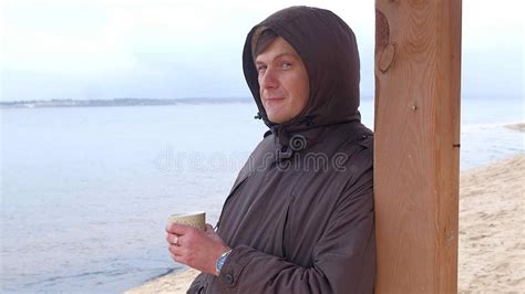 Romantic Young Man Relaxing On The Beach With Drinking Hot Tea Or