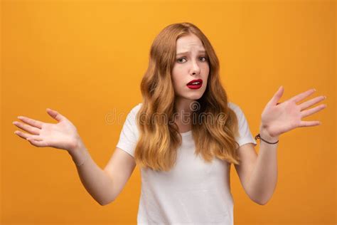 Puzzled Girl Spreads Hands With Doubt Studio Shot Yellow Background