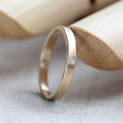 A Gold Wedding Ring Sitting On Top Of A Piece Of Wood