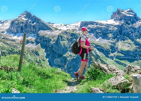 Swiss Alps A Woman With Sticks For A Walk Enjoys Alpine Landscapes Stock Image Image Of