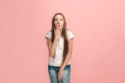 hermosa jovencita mirando sorprendido aislado en rosa foto gratis