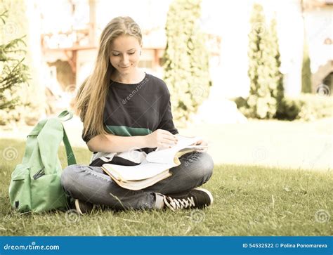 Retro Styled Portrait Of School Or College Girl Sitting On The Grass