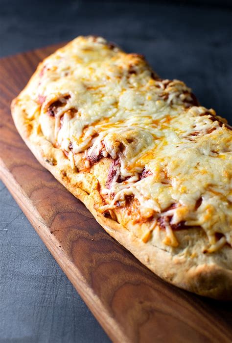 A pizza folded over on itself so it is easy to hold and eat, even for little hands. Chicken Parmesan Calzone Recipe | Kitchen Swagger